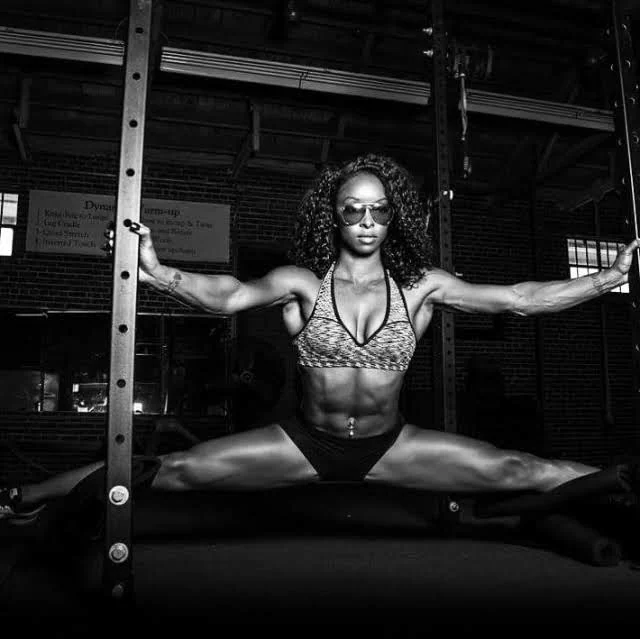 Athlete holding a suspended split between gym uprights