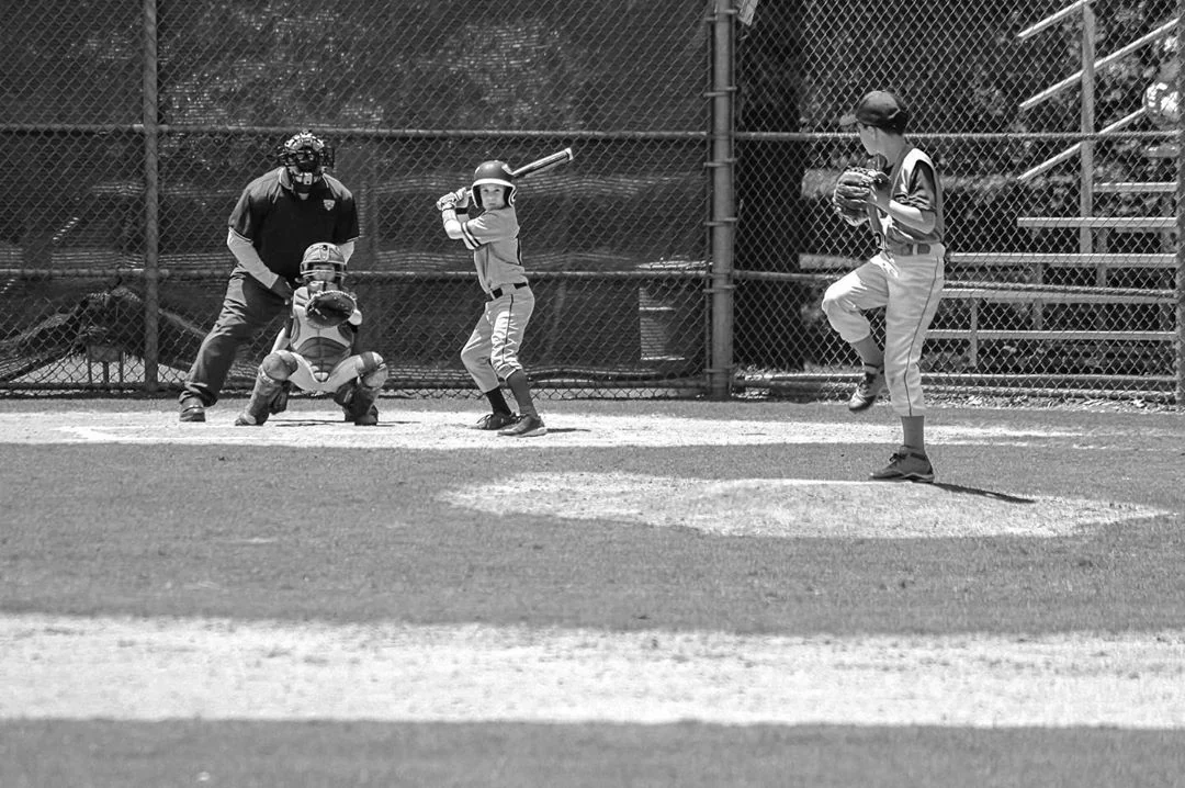 Black and white baseball photograph with pitcher, batter, catcher, and umpire