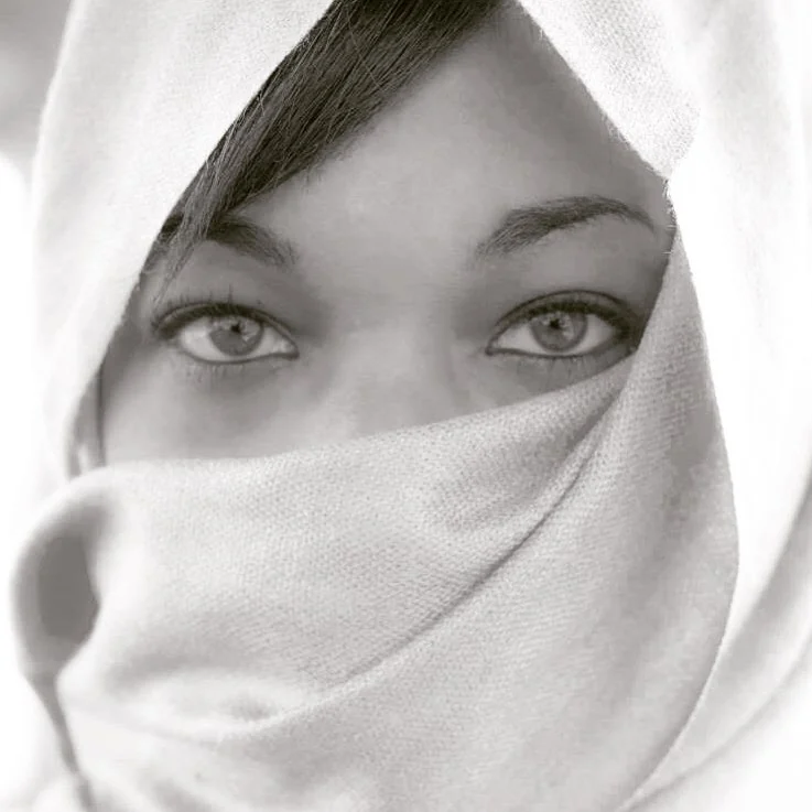 Black and white portrait of eyes above textured fabric