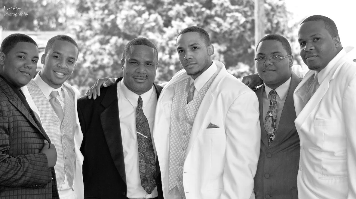 Black and white group portrait of six men in formal wear