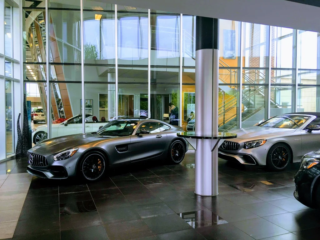 Silver sports cars in a glass-walled showroom