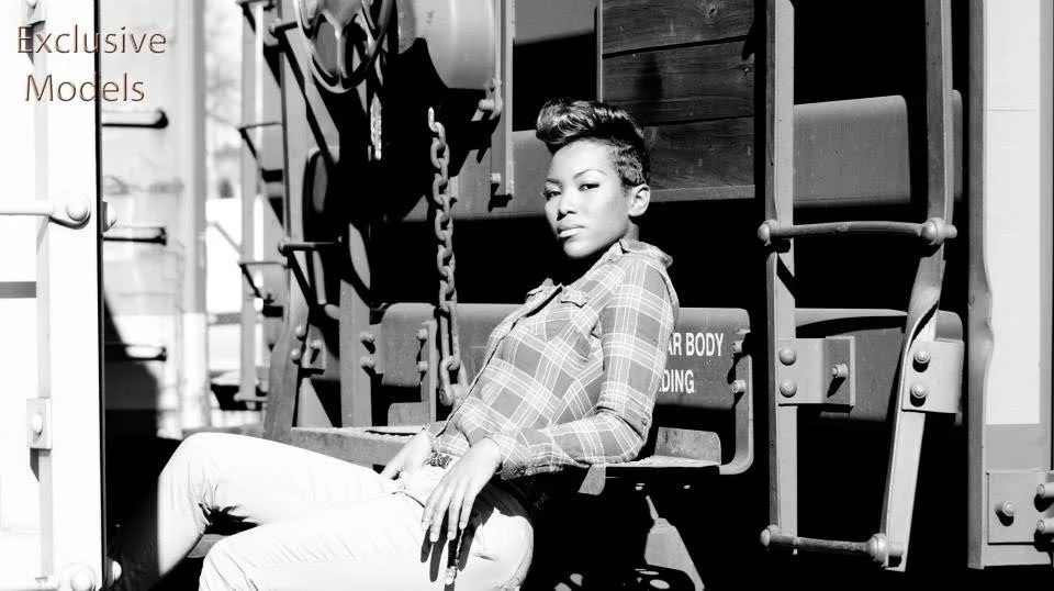 Black and white widescreen portrait against a railcar, with Exclusive Models lettering